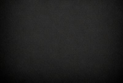 The primary subject of the image is a black background. The setting is a dark room, and the visual style is a black and white photo. The colors and mood of the image are predominantly dark and moody.