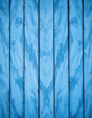The primary subject of the image is a blue wooden wall with a pattern of faces. The setting is a room with a blue wooden wall, and the visual style is a photo. The dominant colors are blue and white, creating a calm and serene atmosphere.