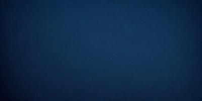 The primary subject of the image is a dark blue sky. The setting is a vast, open space with no visible landmarks or objects. The visual style is a natural, outdoor scene. The colors and mood are predominantly dark and moody, with the blue sky serving as the main focal point.