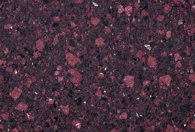The primary subject of the image is a close-up of a marble surface with a red hue. The setting is a rocky surface, possibly a wall or a countertop. The visual style is a close-up of the marble, showcasing its texture and color. The dominant colors are red and black, creating a bold and striking appearance.