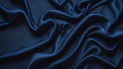 The primary subject of the image is a close-up of a blue fabric, possibly a piece of cloth or a curtain. The setting is a dark background, which contrasts with the blue fabric. The visual style appears to be a close-up of the fabric, showcasing its texture and details. The colors and mood of the image are predominantly blue, creating a calm and serene atmosphere.