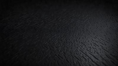 The primary subject of the image is a black leather surface. The setting is a dark room, and the visual style is a close-up of the leather surface. The colors and mood of the image are predominantly dark and moody, with the black leather being the main focus.