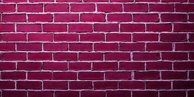 The primary subject of the image is a red brick wall. The setting is a brick wall, and the visual style is a photo. The dominant colors are red and pink, creating a warm and vibrant atmosphere.