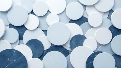 The primary subject of the image is a collection of white and blue circles. The setting is a blue background, and the visual style appears to be a pattern or texture. The dominant colors are white and blue, creating a calm and soothing atmosphere.