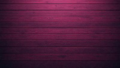 The primary subject of the image is a wooden wall with a purple color. The setting is a room with a wooden floor. The visual style is a close-up of the wooden wall, showcasing its texture and color. The dominant colors are purple and brown, creating a warm and inviting atmosphere.
