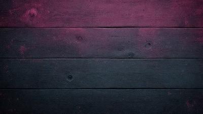 The primary subject of the image is a wooden wall with a black and purple color scheme. The setting is a room with a wooden floor, and the visual style is a close-up of the wooden wall. The colors and mood of the image are dark and moody, with the black and purple hues creating a dramatic atmosphere.