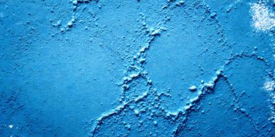 The primary subject of the image is a blue wall with a pattern of white lines. The setting is a room with a blue background. The visual style is a close-up of the blue wall, showcasing the intricate pattern of the white lines. The colors and mood of the image are predominantly blue, creating a calm and serene atmosphere.