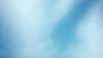 The primary subject of the image is a cloudy blue sky. The setting is a vast expanse of the sky, with no visible land or other objects. The visual style is a natural, outdoor scene, with no indication of digital art or illustration. The colors and mood of the image are predominantly blue, with a slightly overcast atmosphere.