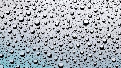 The primary subject of the image is a close-up of a raindrop-filled sky. The setting is a rainy day, and the visual style is a photo. The sky is filled with raindrops, creating a moody atmosphere. The dominant colors are shades of blue and gray, which are often associated with rain and cloudy skies.