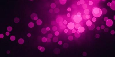 The primary subject of the image is a purple background with a large number of pink and purple dots. The setting appears to be a dark room, with the dots creating a visually striking and vibrant atmosphere. The visual style of the image is a combination of digital art and illustration, with the dots creating a pattern that gives the impression of a light source. The colors and mood of the image are predominantly pink and purple, creating a warm and inviting ambiance.