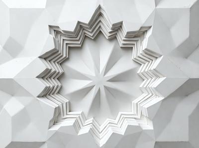 The primary subject of the image is a white, geometric design, possibly a sculpture or a wall art. The setting is a white background, which highlights the intricate details of the design. The visual style appears to be a combination of digital art and illustration, creating a unique and captivating pattern. The colors and mood of the image are predominantly white, giving it a clean and minimalist appearance.