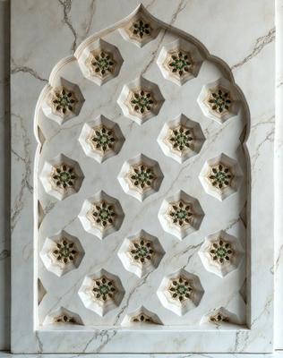 The primary subject of the image is a white marble wall with a pattern of green and white decorations. The setting is a room with a marble wall, and the visual style is a close-up of the wall. The colors and mood of the image are predominantly white and green, creating a clean and fresh atmosphere.