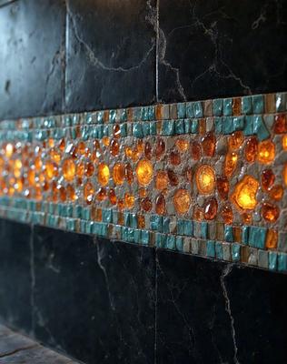 The primary subject of the image is a mosaic tile wall with a black background. The setting is a bathroom, and the visual style is a photo. The dominant colors are orange and blue, creating a warm and inviting atmosphere.