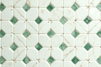 The primary subject of the image is a white tile wall with a green and white pattern. The setting is a bathroom, and the visual style is a photo. The dominant colors are white and green, creating a clean and fresh atmosphere.