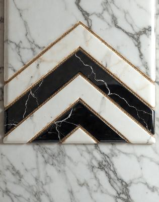 The primary subject of the image is a black and white marble tile with a gold border. The setting is a marble countertop, and the visual style is a close-up of the tile. The dominant colors are black, white, and gold, creating a classic and elegant atmosphere.
