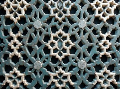 The primary subject of the image is a decorative design featuring a blue and white color scheme. The design is made up of various shapes and patterns, creating a visually appealing and intricate pattern. The setting is a wall, and the visual style appears to be a combination of a photo and digital art, as the design seems to be a part of a larger pattern or decoration. The colors and mood of the image are predominantly blue and white, giving it a clean and elegant appearance.