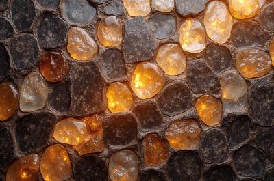 The primary subject of the image is a close-up of a stone wall with a pattern of yellow and orange lights. The setting is a stone wall, and the visual style appears to be a photo. The dominant colors are yellow and orange, creating a warm and inviting atmosphere.