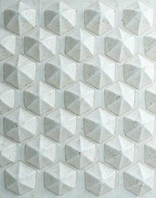 The primary subject of the image is a white marble wall with a pattern of hexagonal shapes. The setting is a white marble wall, and the visual style is a close-up of the marble wall. The colors and mood of the image are predominantly white, giving it a clean and elegant appearance.