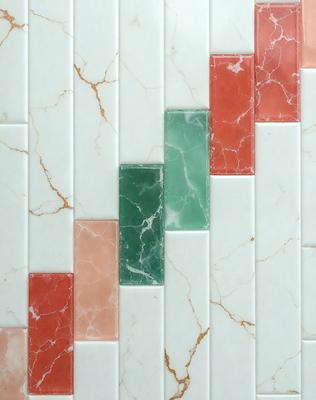 The primary subject of the image is a marble tile wall with a green and red pattern. The setting is a bathroom, and the visual style is a photo. The dominant colors are green and red, creating a vibrant and lively atmosphere.