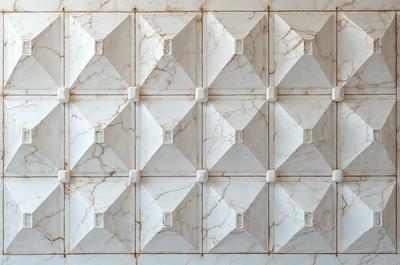 The primary subject of the image is a marble wall with a pattern of squares. The setting is a room with a white marble wall, and the visual style is a photo. The dominant colors are white and beige, creating a clean and elegant atmosphere.