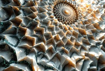 The primary subject of the image is a large, intricate, and colorful design, possibly a sculpture or a piece of art. The design features a combination of white and yellow colors, giving it a vibrant and eye-catching appearance. The setting or background of the image is a marble surface, which adds to the elegance and sophistication of the artwork. The visual style of the image is a close-up, allowing the viewer to appreciate the intricate details of the design. Overall,