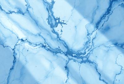 The primary subject of the image is a blue marble tile with a white vein running through it. The setting is a bathroom, as indicated by the presence of the marble tile. The visual style is a close-up of the tile, showcasing its unique pattern and texture. The colors and mood of the image are predominantly blue and white, creating a clean and elegant atmosphere.