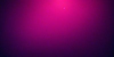 The primary subject of the image is a pink background. The setting is a dark room, and the visual style appears to be a photo. The dominant colors are pink and purple, creating a warm and inviting atmosphere.