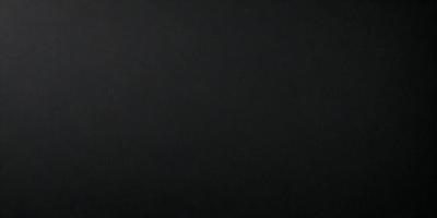 The primary subject of the image is a black background. The setting is a dark room, and the visual style is a black and white photo. The colors and mood of the image are predominantly dark and moody, with a sense of mystery and depth.