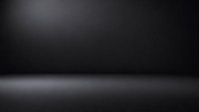 The primary subject of the image is a black wall. The setting is a dark room, and the visual style is a black and white photo. The colors and mood of the image are predominantly dark and moody, with the black wall serving as the focal point.