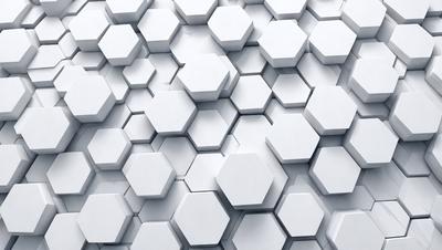 The primary subject of the image is a white wall with a pattern of white hexagons. The setting is a white room, and the visual style is a close-up of the hexagonal pattern. The dominant colors are white, and the overall atmosphere is clean and minimalistic.