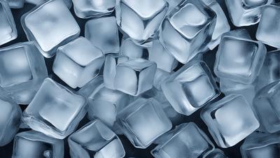 The primary subject of the image is a large pile of clear, blue, and white ice cubes. The ice cubes are arranged in a visually appealing manner, creating a sense of depth and dimension. The setting is a dark background, which contrasts with the bright colors of the ice cubes, making them stand out even more. The visual style of the image is a close-up of the ice cubes, showcasing their unique and intricate patterns. The overall atmosphere of the image is cool and refreshing