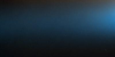 The primary subject of the image is a large, dark blue surface. The setting is a black background, and the visual style appears to be a photo. The dominant colors are blue and black, creating a moody and dramatic atmosphere.
