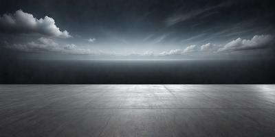 The primary subject of the image is a large body of water, which appears to be a vast ocean. The setting is a concrete platform or pier, which extends out into the water. The visual style of the image is a black and white photo, giving it a classic and timeless appearance. The colors and mood of the image are predominantly dark and moody, with the vast ocean and the pier creating a sense of solitude and tranquility.
