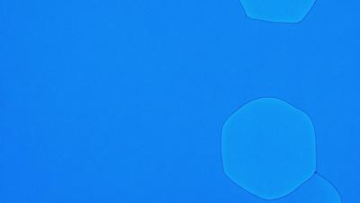 The primary subject of the image is a blue background with a few white circles on it. The setting appears to be a blue sky, and the visual style is a combination of a photo and digital art. The dominant colors are blue and white, creating a calm and serene atmosphere.