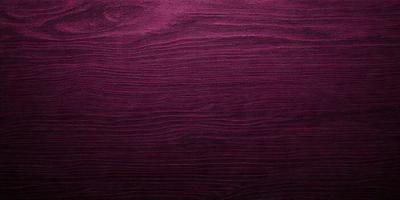 The primary subject of the image is a purple wall with a wood grain texture. The setting is a room with a purple wall, and the visual style is a close-up of the wall. The colors and mood of the image are predominantly purple, creating a calm and soothing atmosphere.
