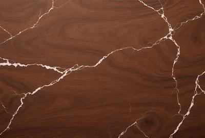 The primary subject of the image is a wooden surface with a marbled pattern. The setting is a room with a wooden floor, and the visual style is a close-up of the wooden surface. The colors and mood of the image are warm and natural, with the wooden surface being the main focus.