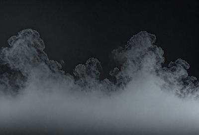 The primary subject of the image is a cloudy sky. The setting is a dark, cloudy night, with the sky being the main focus of the image. The visual style is a black and white photo, which adds a dramatic and moody atmosphere to the scene. The colors and mood of the image are predominantly dark and mysterious, with the clouds and sky being the main elements that create the overall atmosphere.