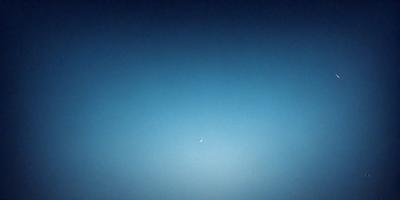 The primary subject of the image is the moon, which is seen in the sky. The setting is a clear blue sky, and the visual style appears to be a painting or drawing. The colors and mood of the image are predominantly blue, creating a serene and peaceful atmosphere.