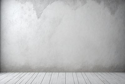 The primary subject of the image is a white wall with a grey texture. The setting is a room with a wooden floor. The visual style is a photo, and the colors and mood are predominantly white and neutral.
