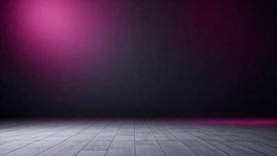 The primary subject of the image is a large, empty stage with a black background. The setting is a theater or a performance venue, and the visual style is a black and white photo. The colors and mood of the image are dark and dramatic, creating a sense of mystery and anticipation.