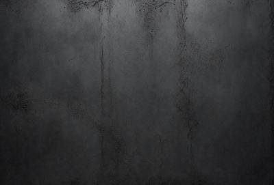 The primary subject of the image is a wall with a gray texture. The setting is a room with a concrete wall, and the visual style is a close-up of the wall. The colors and mood of the image are predominantly gray, giving it a somewhat dull and monotonous appearance.