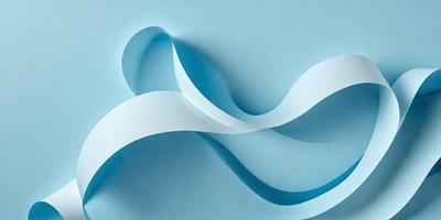 The primary subject of the image is a blue and white paper sculpture, which appears to be a representation of a wave. The sculpture is displayed on a blue surface, giving it a striking contrast. The visual style of the image is a combination of digital art and illustration, as it is a creative representation of a wave. The colors and mood of the image are predominantly blue and white, with a sense of calmness and elegance.
