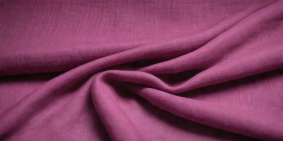 The primary subject of the image is a piece of purple fabric. The setting is a room with a table, and the visual style is a close-up of the fabric. The colors and mood of the image are predominantly purple, creating a calm and serene atmosphere.