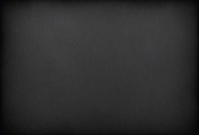 The primary subject of the image is a black background. The setting is a dark room, and the visual style is a black and white photo. The colors and mood of the image are dark and moody, creating a sense of mystery or drama.