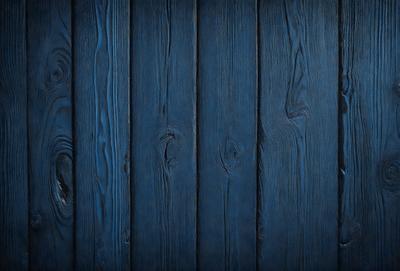 The primary subject of the image is a wooden wall with a blue color. The setting is a room with a blue wooden wall, and the visual style is a photo. The dominant colors are blue and wood, creating a calm and serene atmosphere.