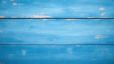 The primary subject of the image is a blue wooden wall. The setting is a room with a blue wooden floor. The visual style is a photo of a wooden wall. The dominant colors are blue and white, creating a calm and serene atmosphere.