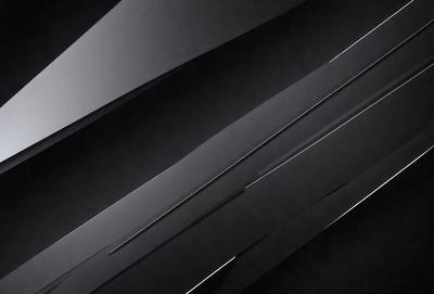 The primary subject of the image is a series of black and white stripes. The setting is a dark background, which contrasts with the stripes. The visual style is a black and white photo, giving it a classic and timeless appearance. The colors and mood of the image are predominantly dark and moody, with the stripes creating a sense of depth and contrast.