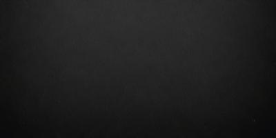 The primary subject of the image is a black background. The setting is a dark room, and the visual style is a black and white photo. The colors and mood of the image are dark and moody, creating a sense of mystery or drama.