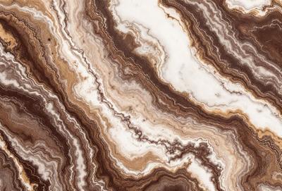 The primary subject of the image is a marble stone with a unique and intricate pattern. The setting is a natural environment, possibly a rock formation or a stone wall. The visual style is a close-up of the marble stone, showcasing its texture and details. The colors and mood of the image are predominantly earthy tones, giving it a natural and timeless appearance.