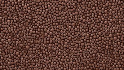 The primary subject of the image is a close-up of a brown surface, which appears to be a wall or a piece of wood. The setting is indoors, and the visual style is a close-up of a patterned surface. The colors and mood of the image are warm and earthy, with the dominant colors being brown and beige.